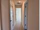 Well-lit hallway with tile flooring leading to various rooms in the home at 13480 Allentown Ave, Port Charlotte, FL 33981