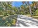 Long driveway leading to house, surrounded by lush greenery at 1811 Music Ln, North Port, FL 34286