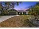 Attractive green house exterior at dusk with landscaping at 1811 Music Ln, North Port, FL 34286