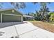 House exterior showcasing a green facade, driveway, and landscaping at 1811 Music Ln, North Port, FL 34286