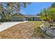 Green house with attached garage, landscaping, and driveway at 1811 Music Ln, North Port, FL 34286
