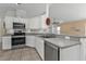 View of kitchen with white cabinets, gray countertops, and stainless steel appliances at 1811 Music Ln, North Port, FL 34286