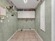 Laundry room with overhead shelving and tile floor at 1811 Music Ln, North Port, FL 34286