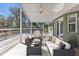 Screened outdoor patio with comfortable seating, ceiling fan and wooded view providing a relaxing outdoor space at 1811 Music Ln, North Port, FL 34286