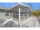 Screened porch with wooden deck and adjacent yard at 1811 Music Ln, North Port, FL 34286