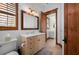 Bathroom featuring dual vanities, white countertop, light wood cabinets, wood-framed mirror, and toilet at 2102 Palm Tree Dr, Punta Gorda, FL 33950