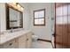 Bathroom featuring marble vanity, white fixtures, wood accents, and window with shutters at 2102 Palm Tree Dr, Punta Gorda, FL 33950