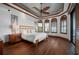 Bedroom with wood floors, plantation shutters, ceiling fan, and arched windows at 2102 Palm Tree Dr, Punta Gorda, FL 33950