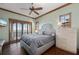 Bedroom with calming water views, balcony access, ceiling fan, and hardwood floors at 2102 Palm Tree Dr, Punta Gorda, FL 33950
