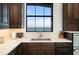Kitchen sink area with white quartz countertops, dark wood cabinets, and ocean view at 2102 Palm Tree Dr, Punta Gorda, FL 33950