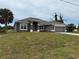 Charming single-story home with a well-manicured lawn, featuring an attached garage at 233 W Pine Valley Ln, Rotonda West, FL 33947