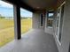 A covered back patio with neutral colors overlooks a grassy backyard at 233 W Pine Valley Ln, Rotonda West, FL 33947