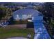 Aerial view of a single-story home with a gray roof and white exterior, showcasing a driveway and landscaping at 3004 Banyan Way, Punta Gorda, FL 33950