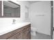 Modern bathroom with wood vanity, white sink, and a glass-enclosed shower at 3004 Banyan Way, Punta Gorda, FL 33950