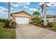 Attractive single-story home with a two-car garage, lush landscaping, and palm trees at 3310 Tripoli Blvd, Punta Gorda, FL 33950