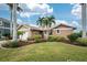 Single-story home with a two-car garage, landscaped yard, and palm trees under a blue sky at 3310 Tripoli Blvd, Punta Gorda, FL 33950