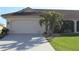 White two-car garage with palm trees and a manicured lawn at 3448 Nighthawk Ct, Punta Gorda, FL 33950