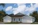 Two-car garage, light blue exterior, and a dark brown roof at 2051 Royal Tern Cir, Punta Gorda, FL 33983