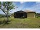 View of the backyard of the house with a screened porch, attached to the house, with potted plants inside the screen at 25115 Esmeralda Ct, Punta Gorda, FL 33955
