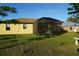 View of the backyard featuring a screened-in lanai with outdoor furniture and beautiful green grass at 25115 Esmeralda Ct, Punta Gorda, FL 33955
