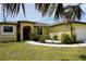 Charming one-story home featuring a well-maintained lawn, colorful landscaping, and a welcoming walkway at 25115 Esmeralda Ct, Punta Gorda, FL 33955