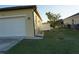 Attached garage with white door and side yard with gravel landscaping at 25115 Esmeralda Ct, Punta Gorda, FL 33955