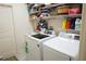 Laundry room with washer, dryer, and ample storage shelves at 25115 Esmeralda Ct, Punta Gorda, FL 33955