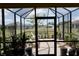 View of the screened-in lanai with brick flooring and potted plants, offering a relaxing outdoor space at 25115 Esmeralda Ct, Punta Gorda, FL 33955