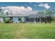 The home's exterior boasts a light blue color, a screened-in pool, and a large backyard at 27545 Monte Cristo Blvd, Punta Gorda, FL 33955