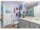 Charming bathroom with gray vanity, tiled floor, and exterior access at 27545 Monte Cristo Blvd, Punta Gorda, FL 33955