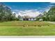 Ranch style home with light blue exterior, spacious yard, and mature trees at 27545 Monte Cristo Blvd, Punta Gorda, FL 33955
