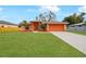 Single story home with orange exterior, landscaped lawn, and driveway at 3474 Catskill St, Port Charlotte, FL 33952