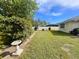 Spacious backyard with lush green lawn and privacy hedges, with a sitting area at the back fence at 3980 Champagne Ave, North Port, FL 34287