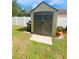 Backyard shed with double doors, concrete ramp, and white vinyl fence at 3980 Champagne Ave, North Port, FL 34287