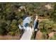 Aerial view of home with metal roof, two-car garage, and lush landscaping at 17221 Elder Ave, Port Charlotte, FL 33954