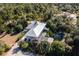 Aerial view of home showcasing metal roof, pool, and lush landscaping at 17221 Elder Ave, Port Charlotte, FL 33954
