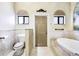 Bathroom with a large bathtub, toilet and a door at 17221 Elder Ave, Port Charlotte, FL 33954