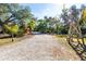 Gravel driveway leads through lush landscaping to a charming home at 17221 Elder Ave, Port Charlotte, FL 33954