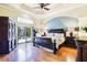 Large main bedroom with a ceiling fan, wood floors, and access to the pool area at 17221 Elder Ave, Port Charlotte, FL 33954