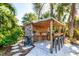 Covered outdoor bar area with bar stools and lush tropical backdrop at 17221 Elder Ave, Port Charlotte, FL 33954