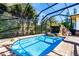 Inviting screened pool area with a stone waterfall feature at 17221 Elder Ave, Port Charlotte, FL 33954