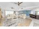 Open living room with light beige couches, wood flooring, and a view of the kitchen at 17260 Vagabond Cir, Punta Gorda, FL 33955