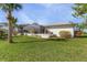 Backyard with lush green lawn, palm trees, and screened-in pool area at 17466 Fuego Ln, Punta Gorda, FL 33955