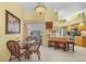 Dining area with glass-top table, wicker chairs, and view of the kitchen at 17466 Fuego Ln, Punta Gorda, FL 33955
