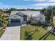 Front exterior of a two-story home with a metal roof, a two-car garage, and a landscaped yard at 17466 Fuego Ln, Punta Gorda, FL 33955