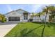 Inviting front yard with palm trees and a well-maintained lawn at 17466 Fuego Ln, Punta Gorda, FL 33955