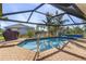 Covered pool with a grill, brick pavers, and a view of the neighboring homes at 17466 Fuego Ln, Punta Gorda, FL 33955