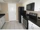 Kitchen features white cabinets, black appliances, and granite countertops at 21471 Dranson Ave, Port Charlotte, FL 33952