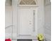 White front door with sidelights and holiday plants at 4317 Eldron Ave, North Port, FL 34286