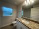 Bathroom featuring granite countertop, modern fixtures, a toilet, and window at 507 San Ambrosio St, Punta Gorda, FL 33983